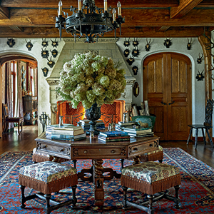 A designed room with an elaborate flower centerpiece on the table.